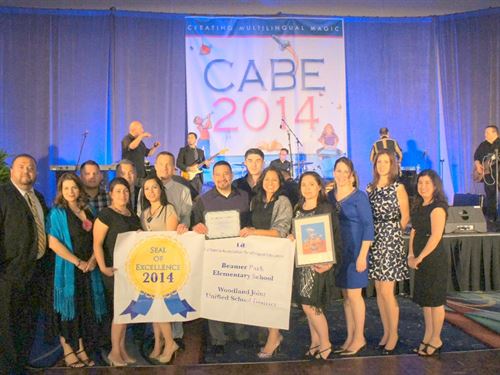 Students holding large certificates for CABE 2014 in nice attire. 